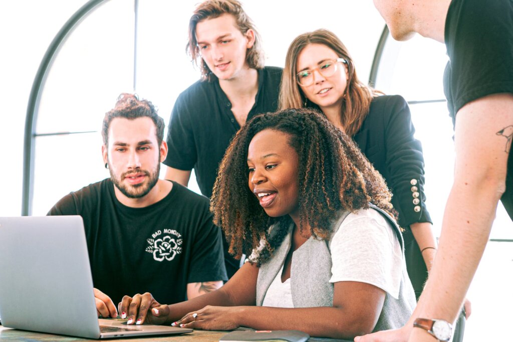 equipe de trabalho reunida em frente a um notebook